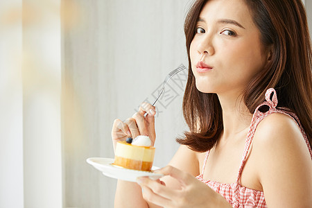 吃着甜品蛋糕的年轻女子图片