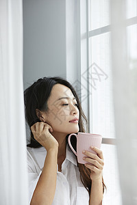 窗边喝茶的女人图片