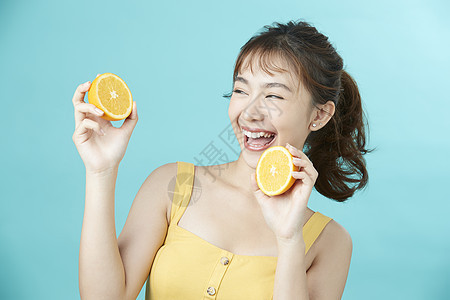 可爱女孩开心举着橙子脸部护理高清图片素材