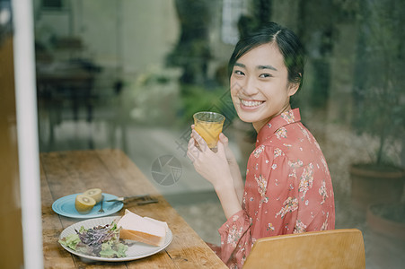 鲜榨橙汁室内用餐的女人背景