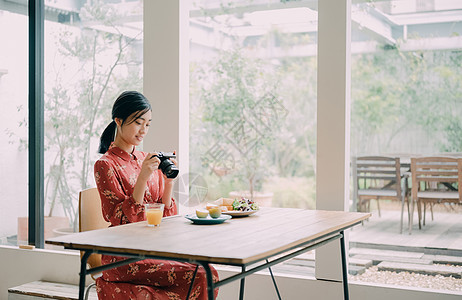 室内拍摄美食的女人图片