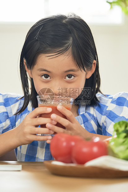 室内可爱的小女孩喝果汁图片