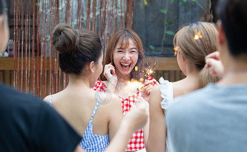 派对上放烟花开心的年轻女子图片