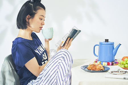 居家阅读喝咖啡的青年女子图片