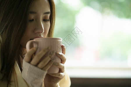 女孩端着水杯喝水照图片