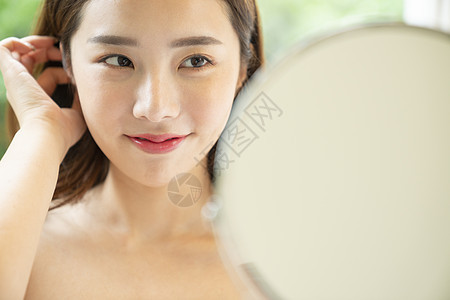 脸部护理湿润肌肤的年轻女子图片