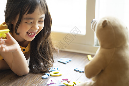 小女孩和玩具熊一起学习认识字母背景