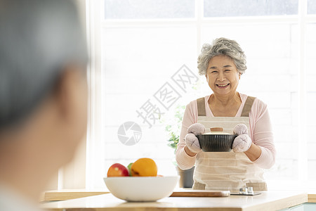 端着锅微笑的老年女性图片