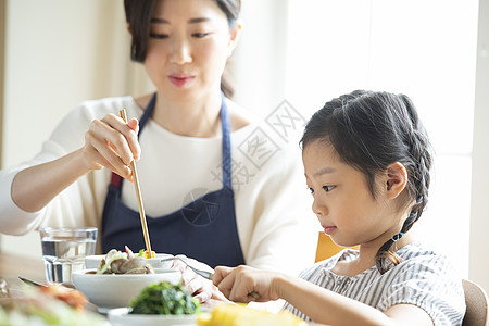 孩子吃饭餐桌上吃饭的母女背景