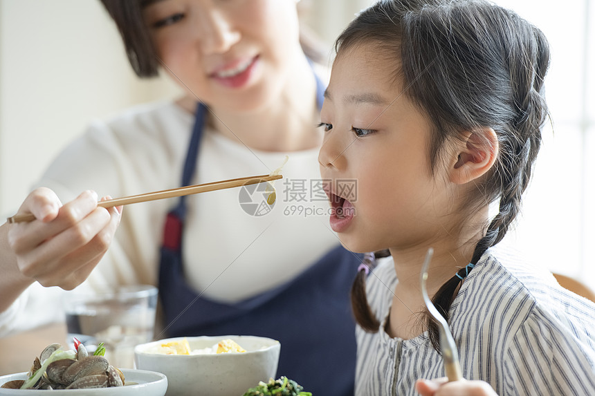 母亲照顾女儿吃饭喂饭图片