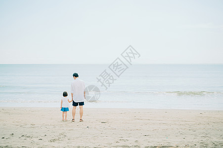 海滩上手牵手的父女背影图片