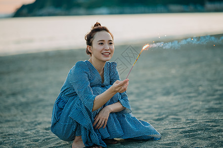 海滩上放烟花的年轻女子图片
