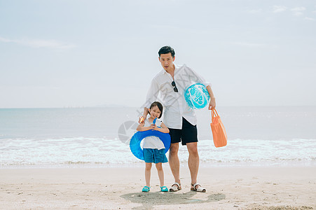 掌握沙滩球带来享受海水浴的家庭图片