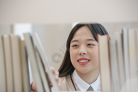 高中女生查阅书架上的书图片