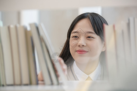 高中女生查阅书架上的书图片