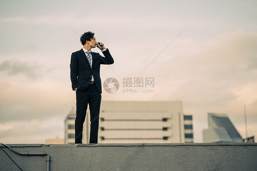 户外天台喝咖啡的商务男士图片