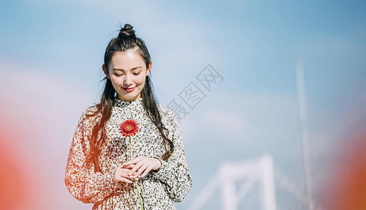 胸前拿着鲜花的青年女子图片