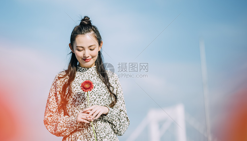 胸前拿着鲜花的青年女子图片