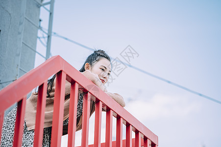 靠在栏杆上的年轻女子图片