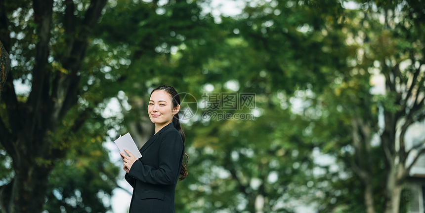 拿着书微笑的职业女性图片