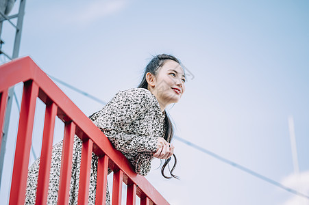 户外靠在栏杆上的青年女子图片