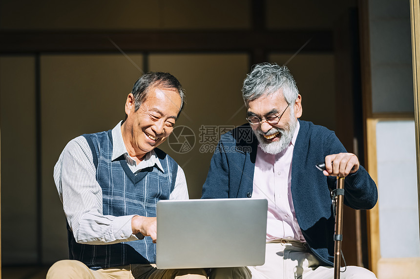 房屋快乐的人物老人和他的朋友看着个人计算机图片