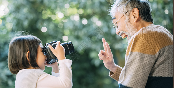 孙女用相机给爷爷拍照图片