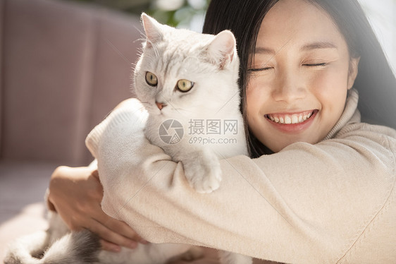 青年好朋友笑容和猫一起生活的年轻女子图片