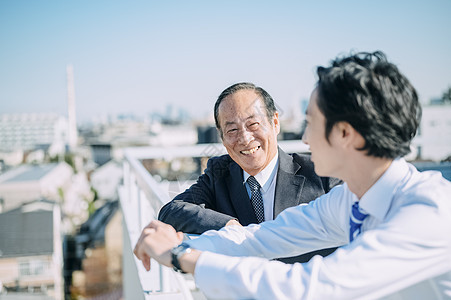 天台上聊天的商务男士图片