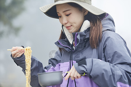 年轻女人徒步登山探险吃东西图片