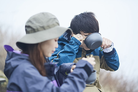 两个年轻人徒步登山休息吃面图片