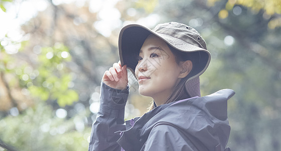 绿树林年轻女人徒步登山探险背景