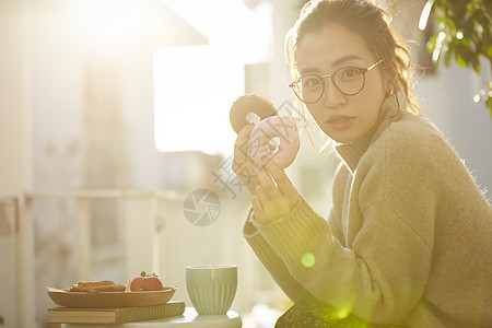 拿着甜甜圈的青年女子图片