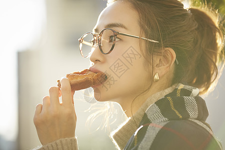 吃着面包的青年女子图片