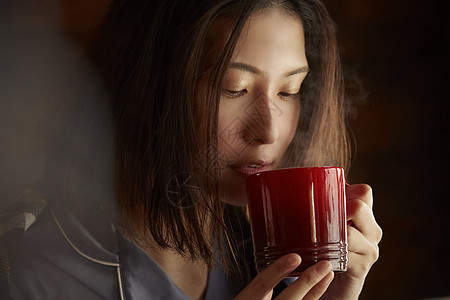 青年女子低头喝咖啡背景图片