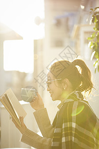 户外阅读喝咖啡的女青年图片