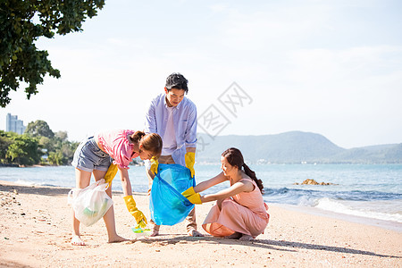 海滩上捡垃圾的年轻男女图片