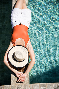 年轻闪闪发光的外国人一个女人在游泳池旁放松的泳装图片