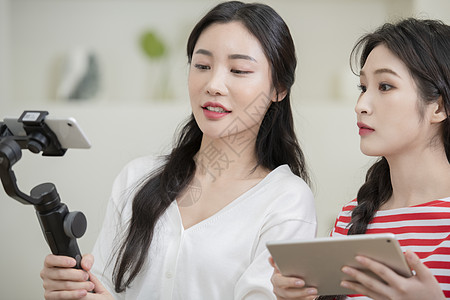 拍摄烹饪做菜短视频的年轻女子图片