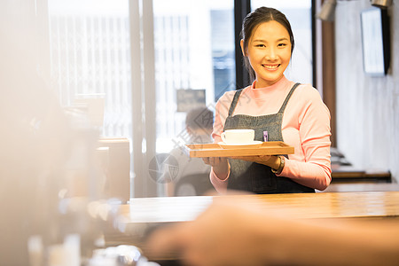 咖啡馆女店员端着托盘微笑图片