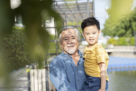 老人抱着孙子在户外散步图片