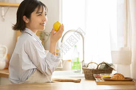 厨房拿着柠檬的青年女子图片