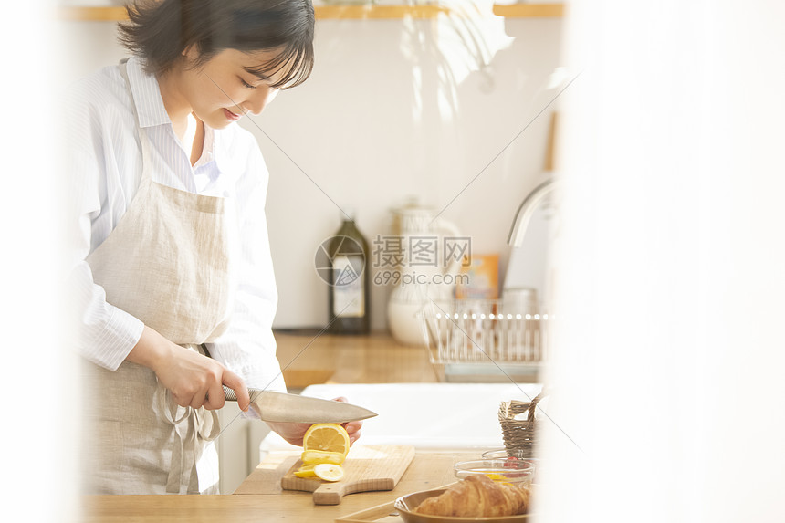 年轻女子厨房切柠檬图片