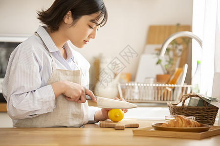 年轻女子厨房切柠檬图片