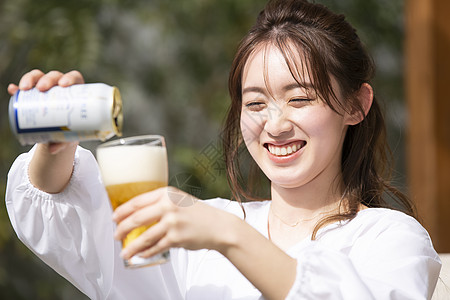 倒啤酒开心的年轻女子背景图片