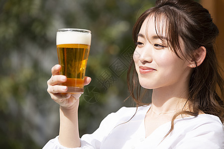拿着啤酒微笑的年轻女子图片