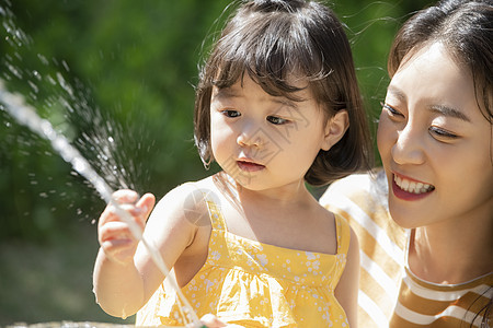 夏天户外玩水的母亲和女儿图片