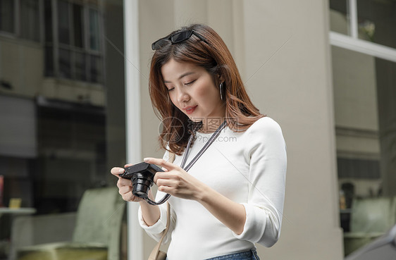 拿着相机微笑的青年女子图片