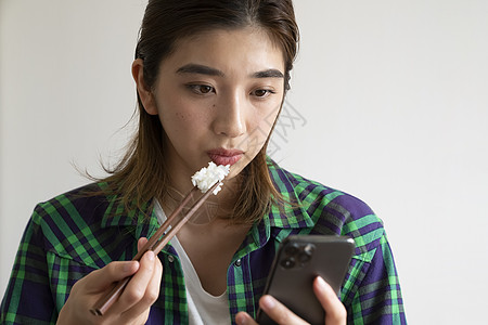 吃饭看手机的年轻女子图片