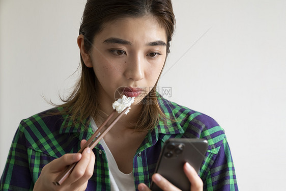 吃饭看手机的年轻女子图片